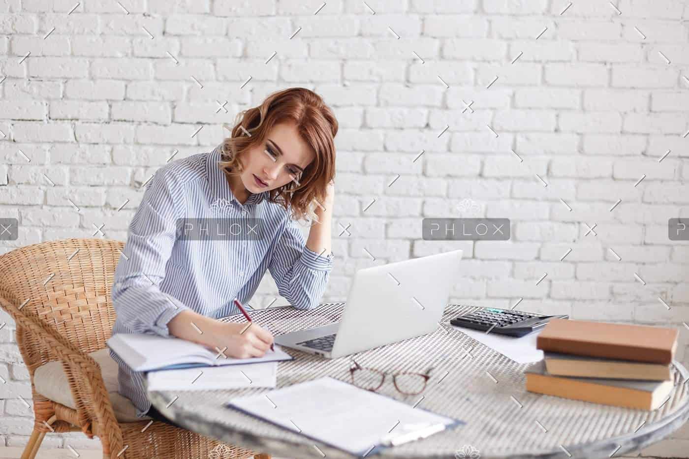Woman freelancer writing with pen