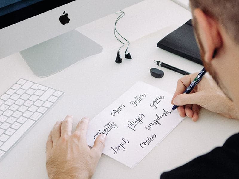 A man designing a brand logo with calligraphy