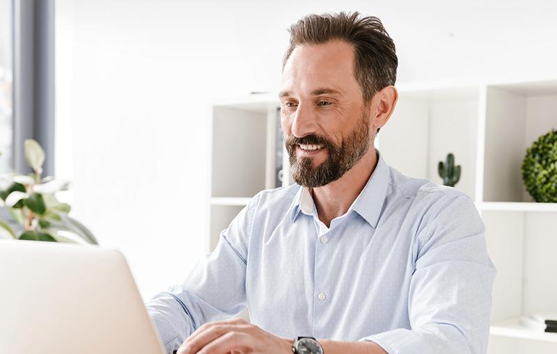 A man smiling at his computer